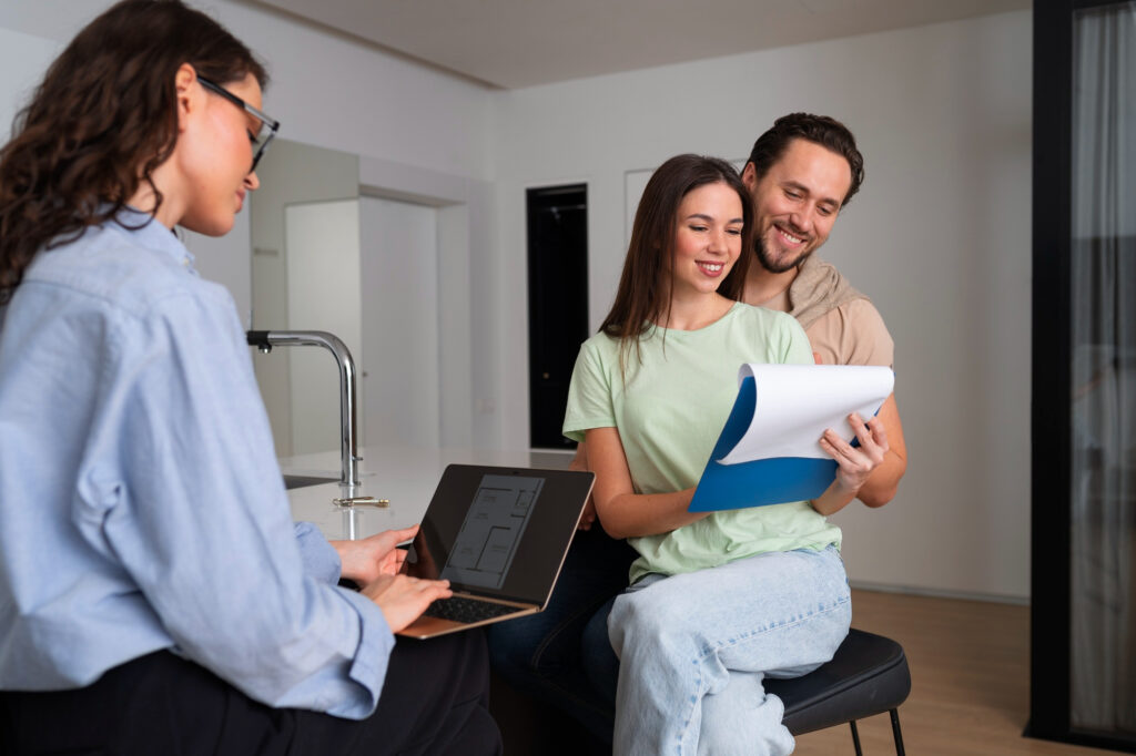 A financial advisor discusses refinancing options with a couple reviewing documents in a modern kitchen