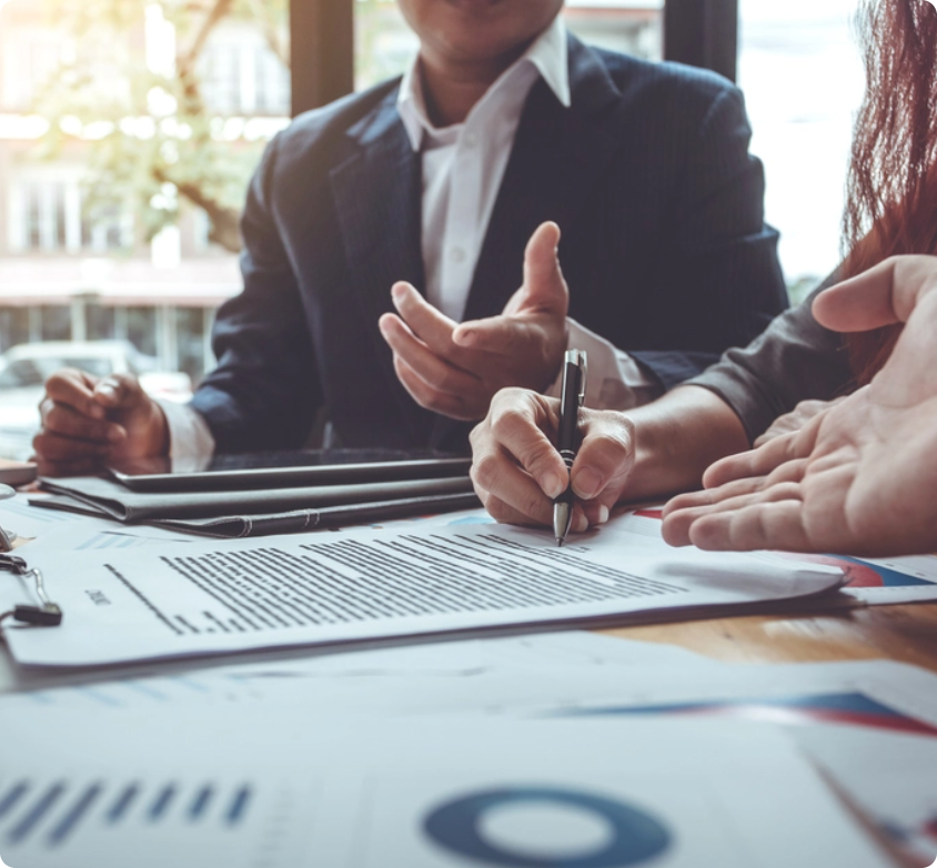 Business professionals discussing loan options and signing documents at a meeting in Australia.