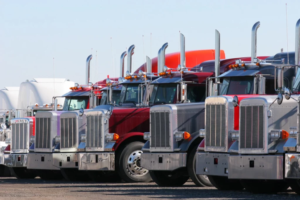 A row of red and silver semi-trailer trucks illustrating asset finance options for australian businesses.