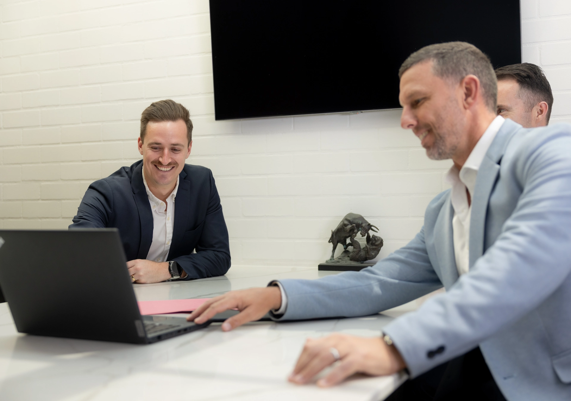 Business professionals discussing investment property loan strategies in a modern office.
