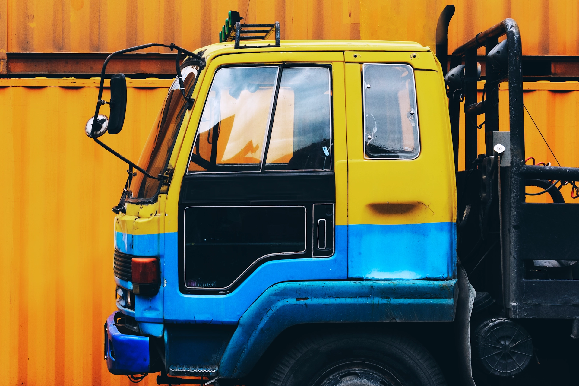 Yellow truck parked near a yellow container, illustrating asset finance options for businesses.