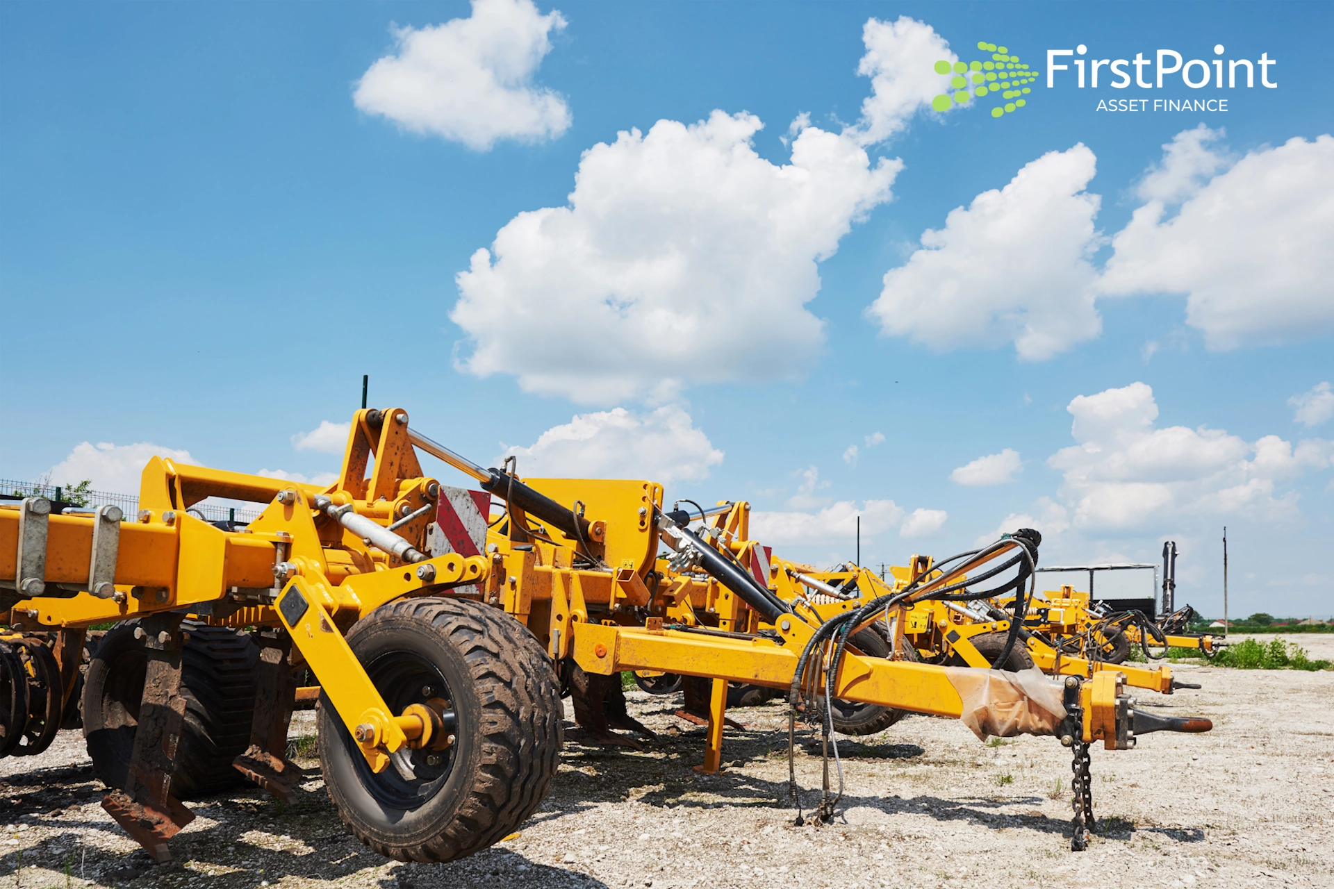 Yellow agricultural equipment in a field under a blue sky, representing asset finance options for