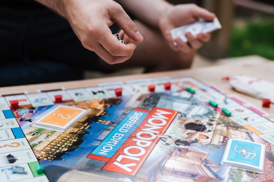 Board game pieces and cards on a table, illustrating buyer decision‑making and rising listings easing property market FOMO.